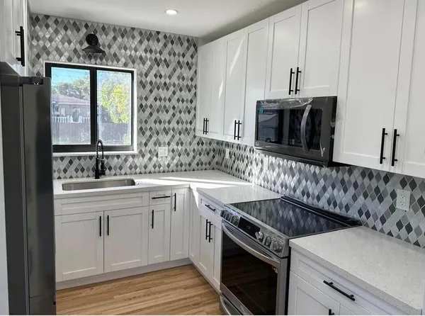 a kitchen with a sink stove and cabinets