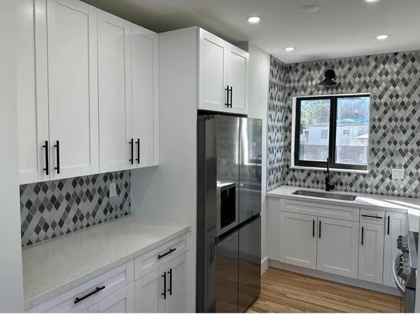a kitchen with white cabinets and stainless steel appliances