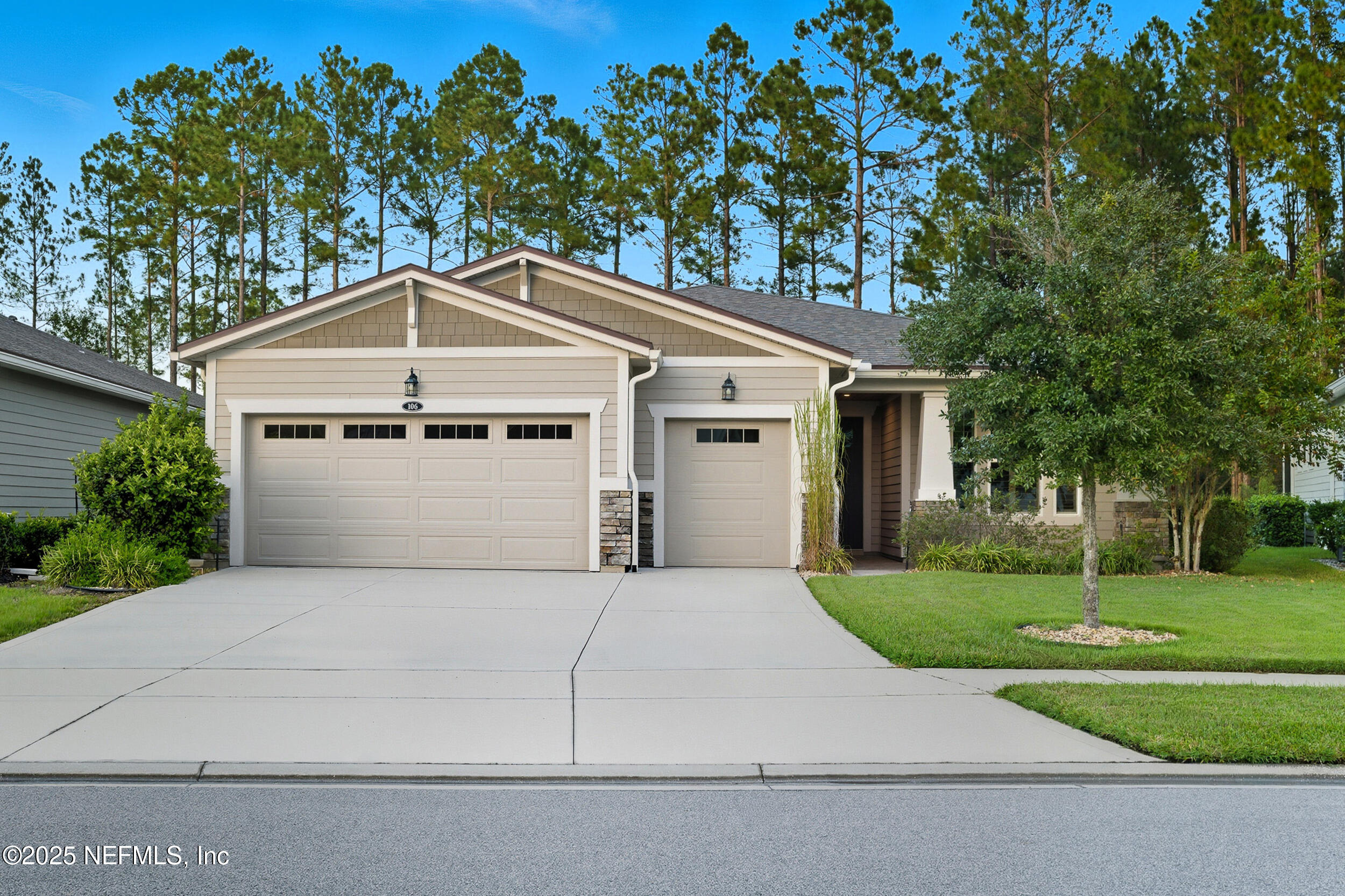 a front view of a house with a yard garage and trees
