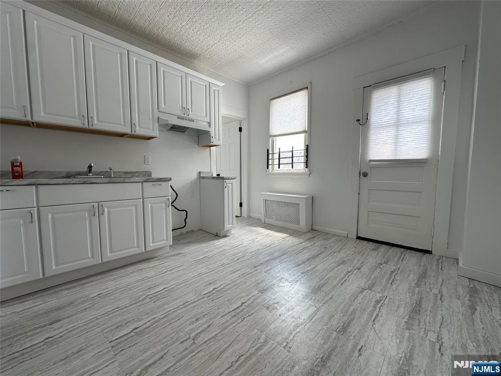 a kitchen with cabinets and wooden floor