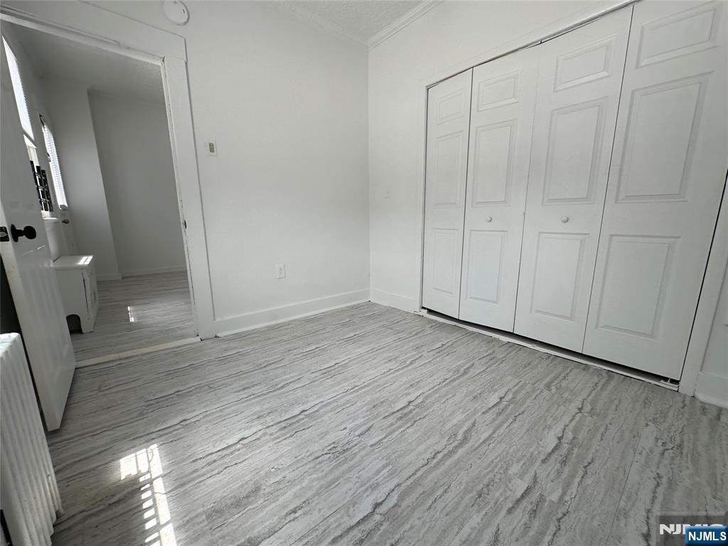 526 Valley Brook Avenue, Unit 2 Lyndhurst, NJ 07071 - Photo 11 of 13 a view of an empty room with wooden floor and a window
