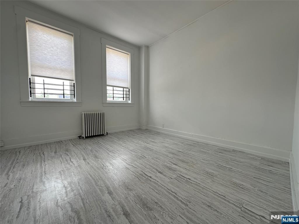 526 Valley Brook Avenue, Unit 2 Lyndhurst, NJ 07071 - Photo 9 of 13 an empty room with wooden floor and windows