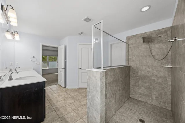 a bathroom with a double vanity sink a mirror and a shower