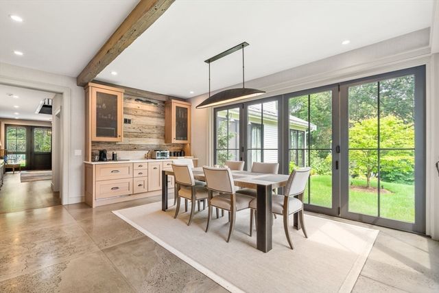 a view of a dining room and livingroom with furniture large windows a chandelier