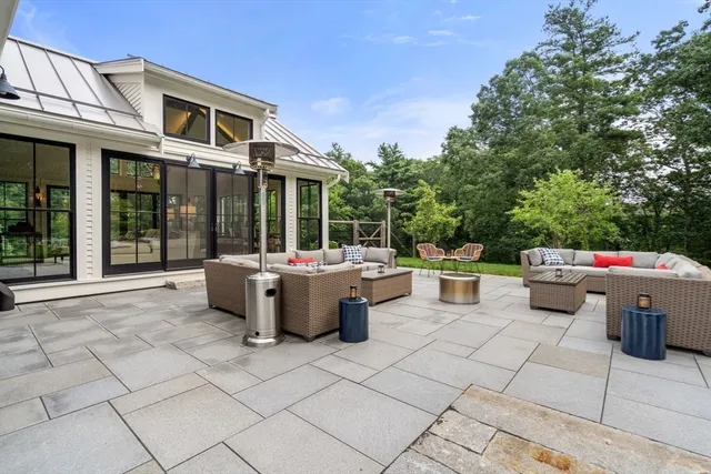 a view of a patio with a dining table and chairs with a small yard
