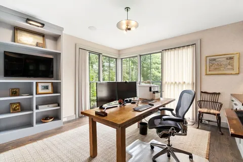 a view of a livingroom with workspace and a window