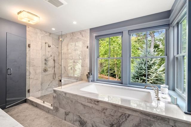 a spacious bathroom with a large tub shower and sink