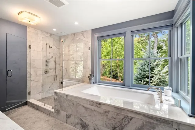 a spacious bathroom with a large tub shower and sink