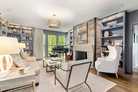 a living room with fireplace furniture and a large window