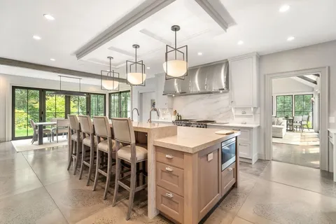 a kitchen with lots of wooden furniture cabinets and stainless steel appliances