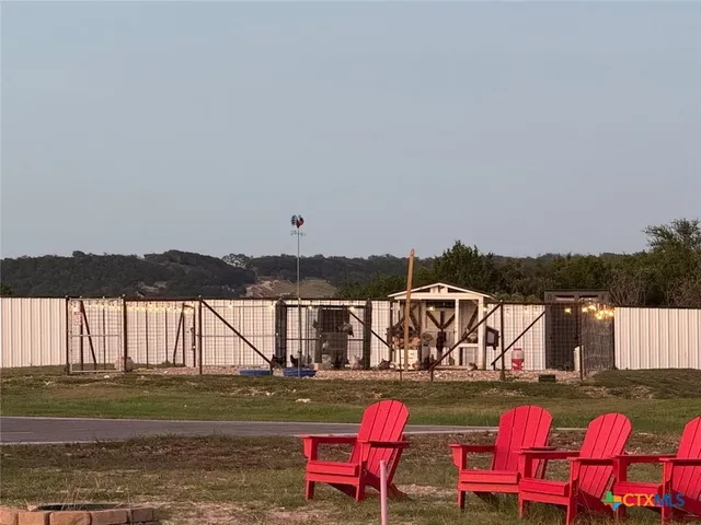 a view of a swimming pool with a chairs and wooden fence
