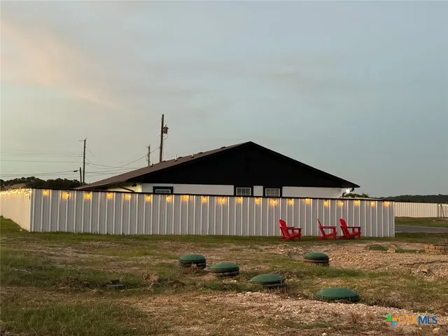 a view of a swimming pool with a chairs and wooden fence