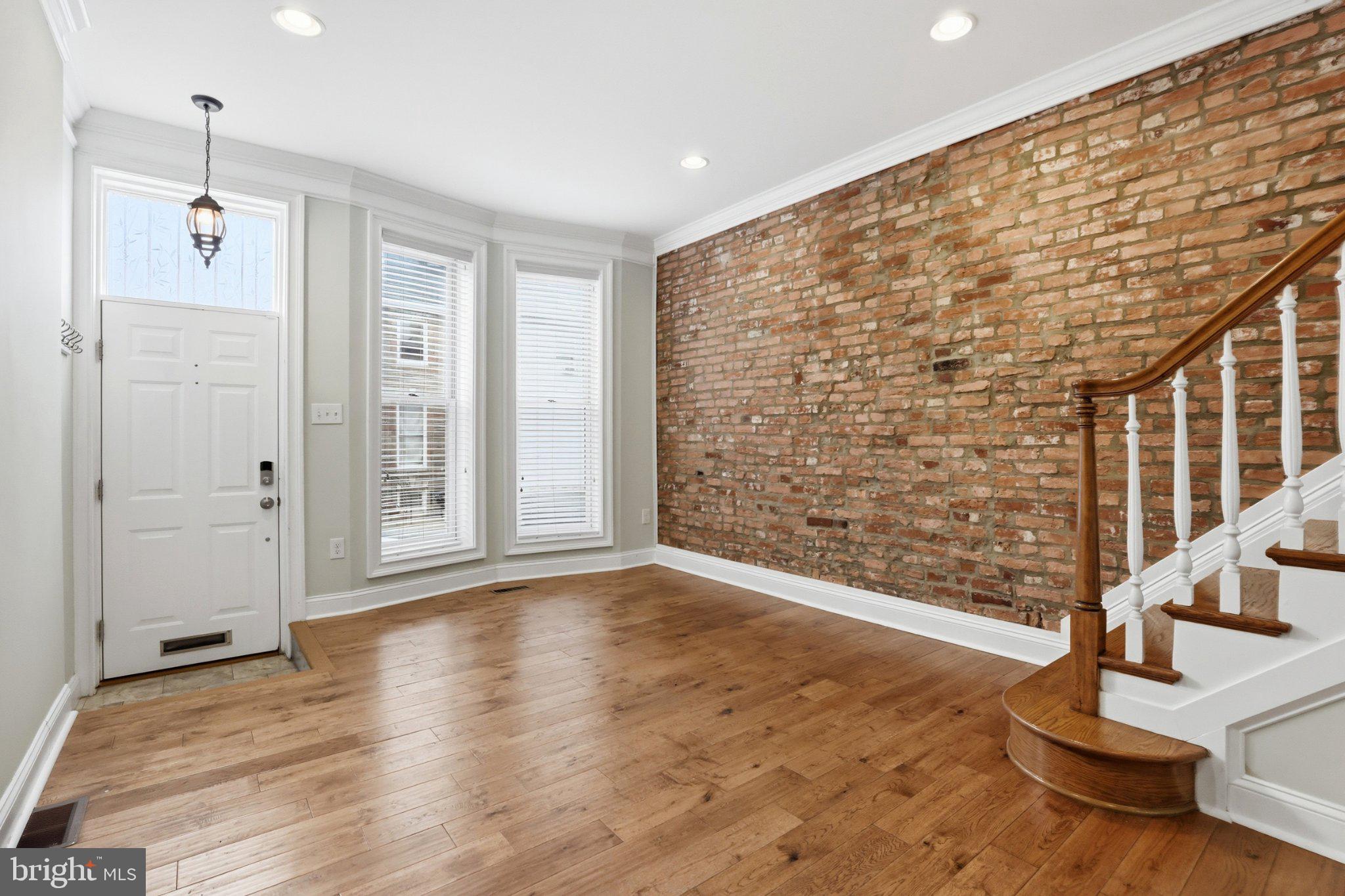 222 South Exeter Street Baltimore, MD 21202 - Photo 3 of 41 a view of an empty room with wooden floor and a window