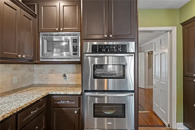 a kitchen with stainless steel appliances granite countertop a stove and a microwave