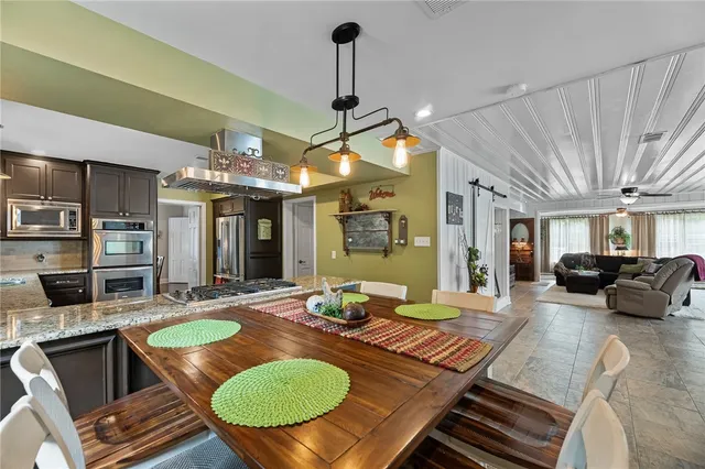 a living room with furniture a table and kitchen view