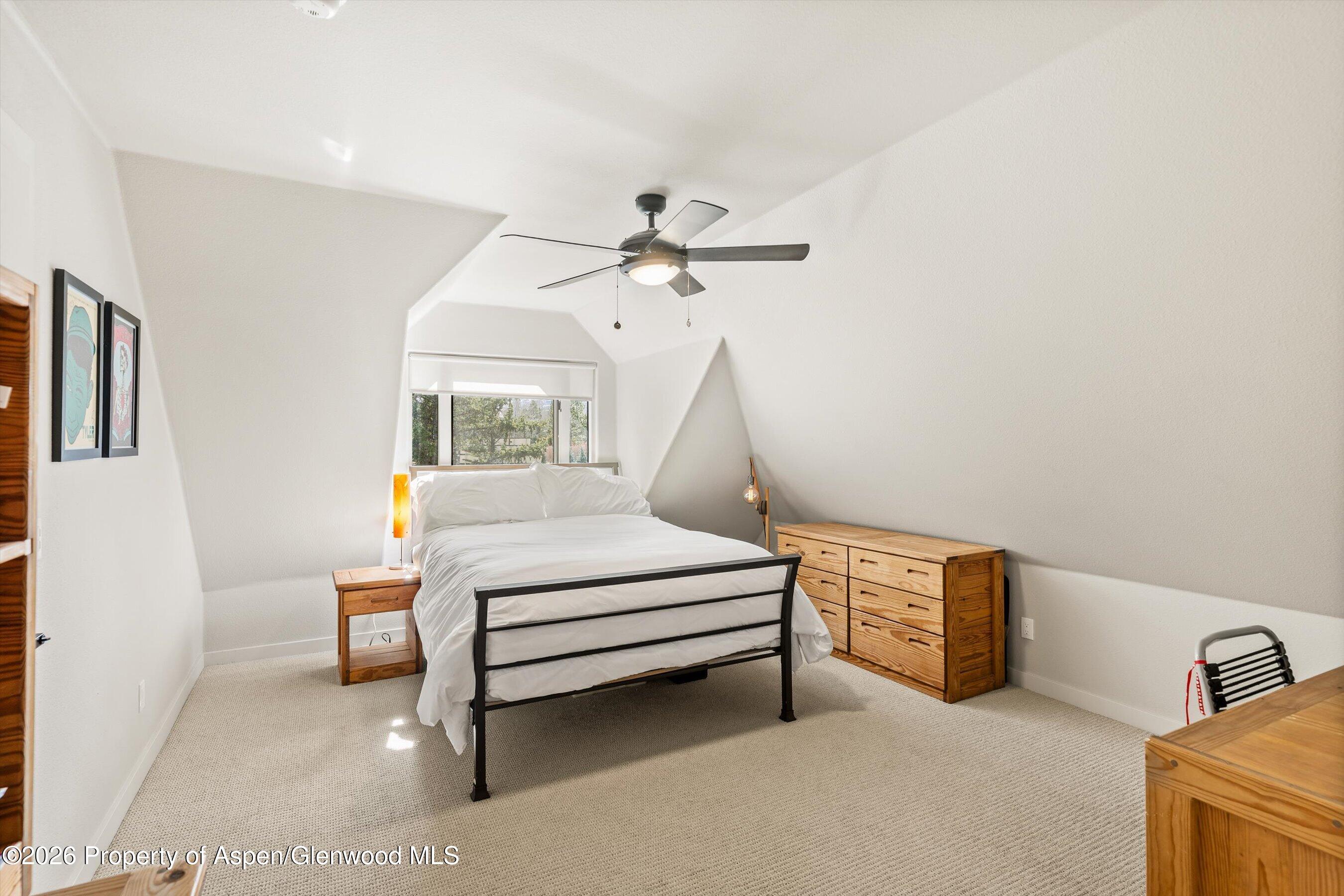 90 Alexander Avenue Snowmass, CO 81654 - Photo 15 of 26 a bedroom with a bed and a chandelier