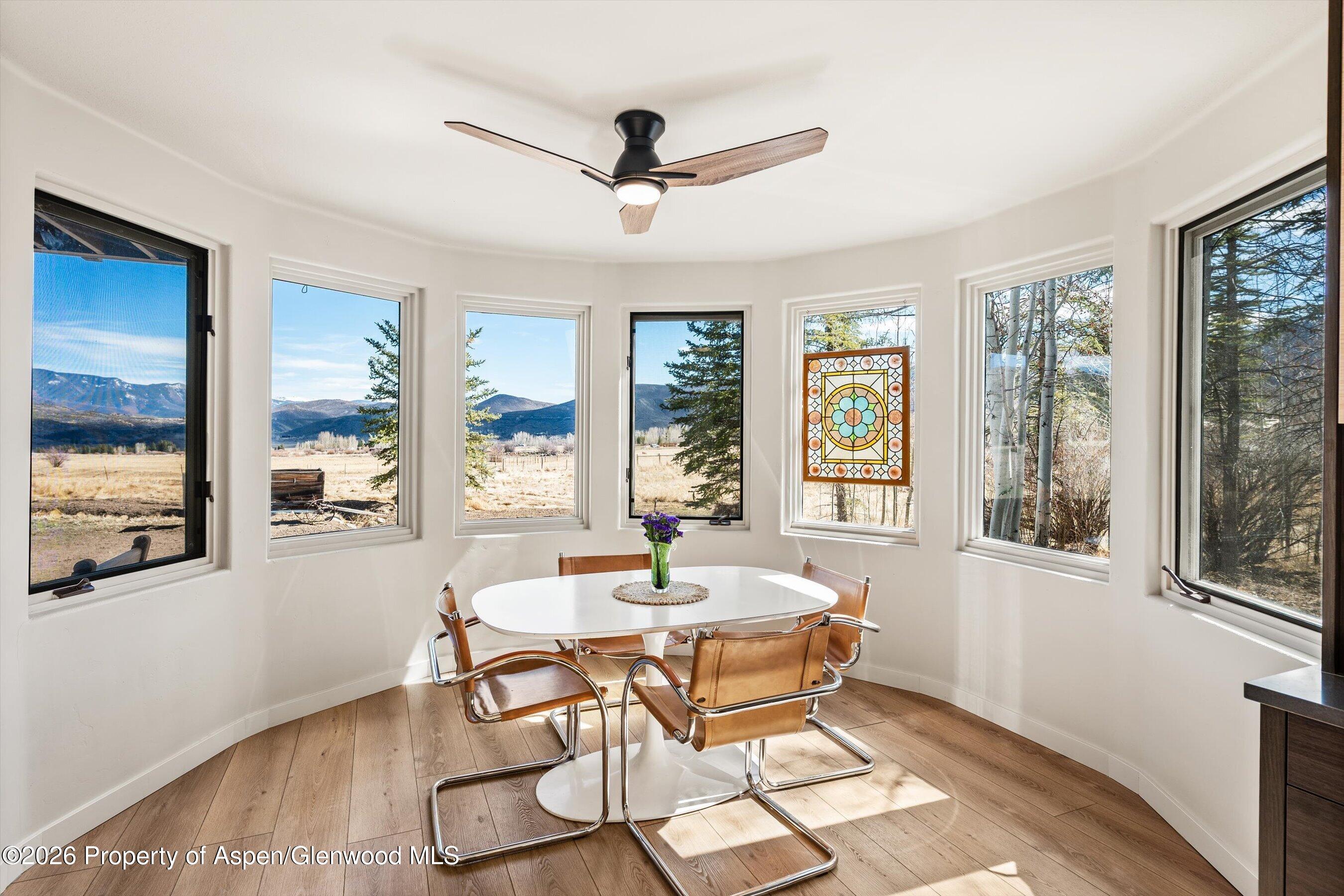 90 Alexander Avenue Snowmass, CO 81654 - Photo 9 of 26 a dining room with wooden floor a chandelier fan a wooden table and chairs