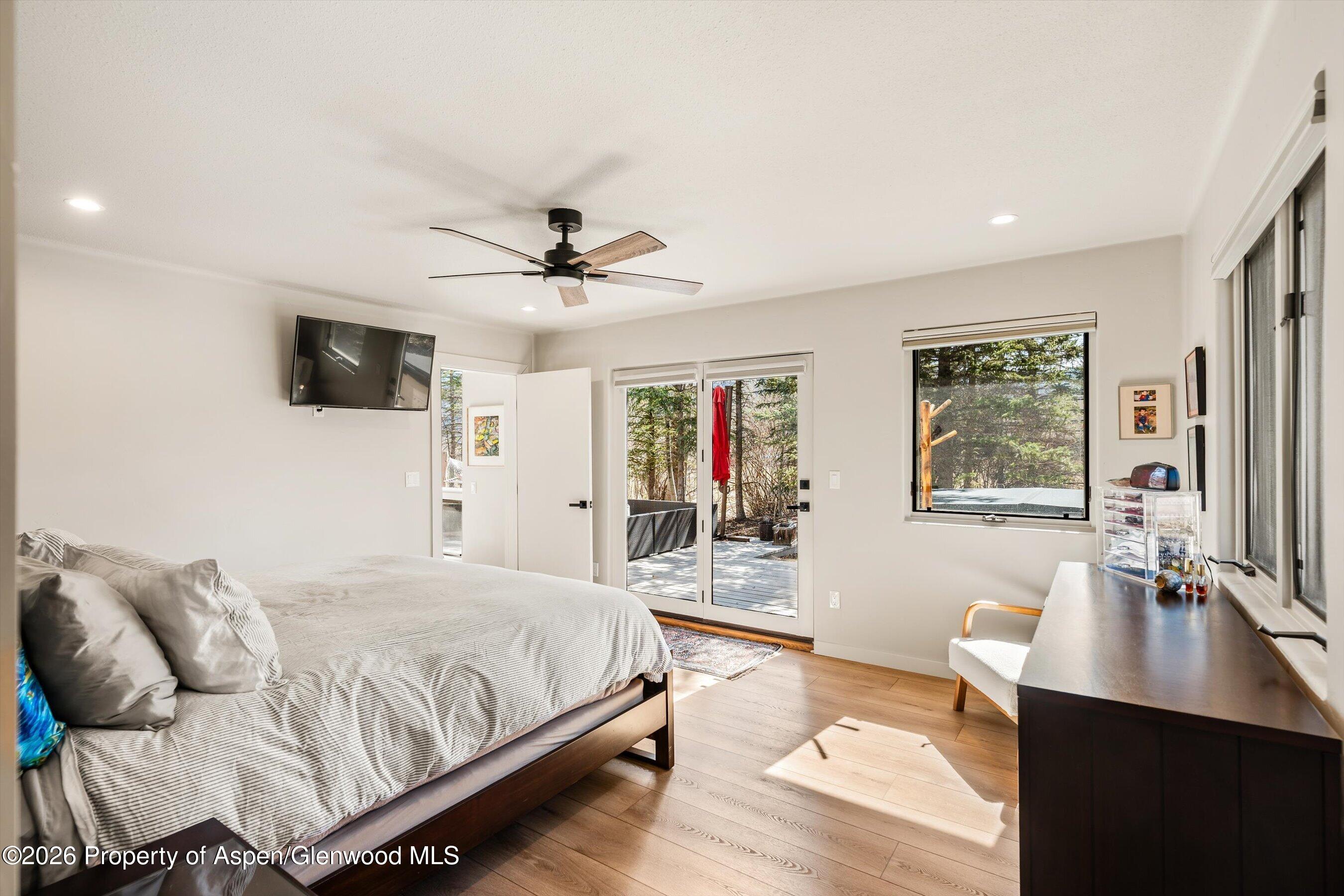 90 Alexander Avenue Snowmass, CO 81654 - Photo 10 of 26 a spacious bedroom with a large bed a flat tv screen and a dresser