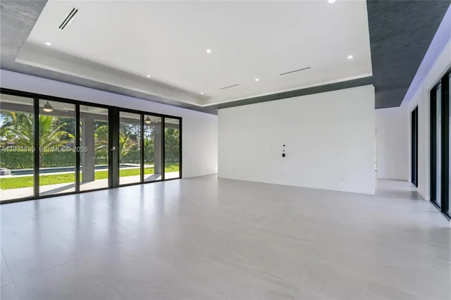 a view of an empty room with a window and a ceiling fan