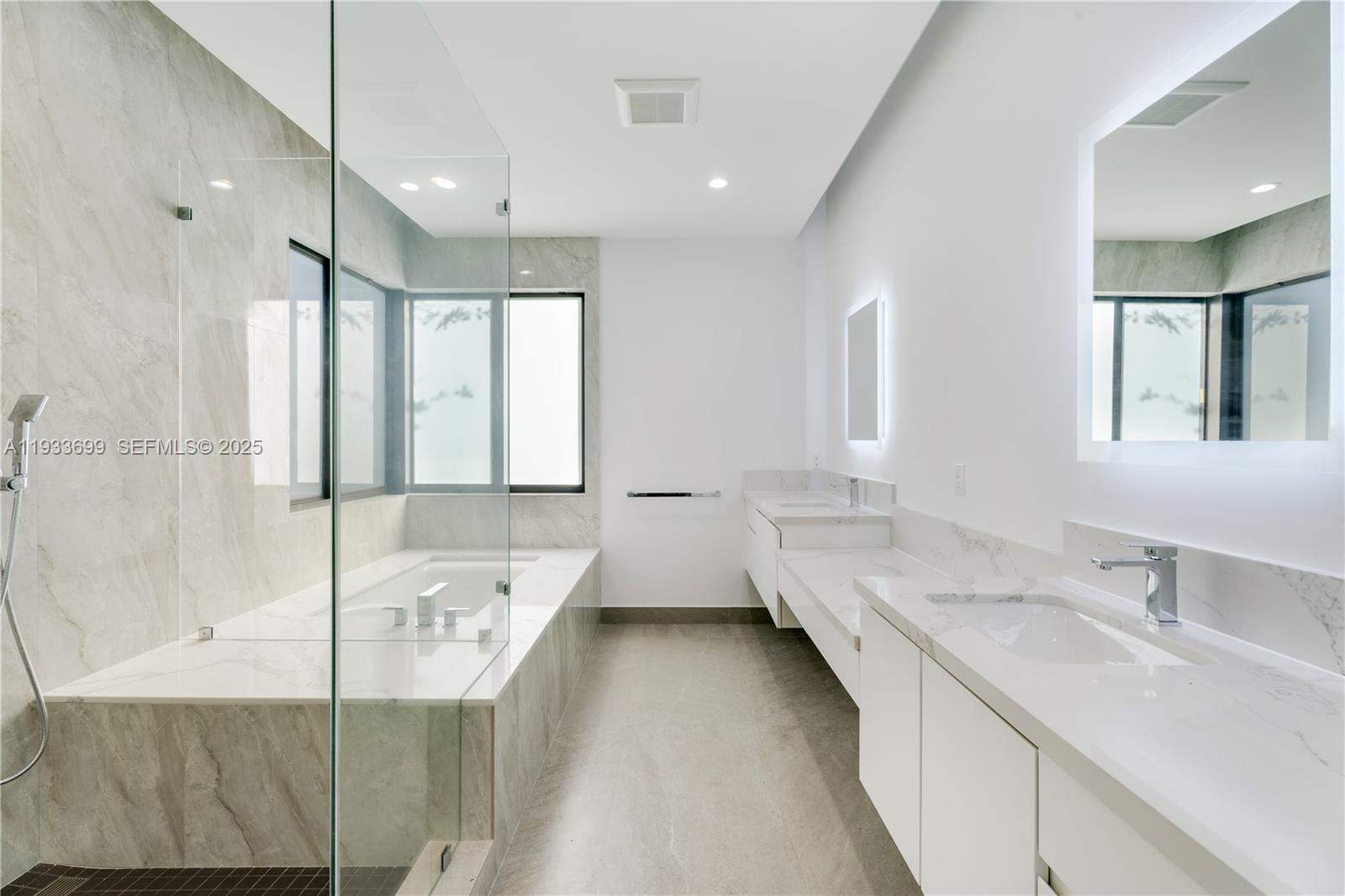 10398 Southwest 64th Street Miami, FL 33173 - Photo 37 of 88 a bathroom with a double vanity sink and mirror with bathtub