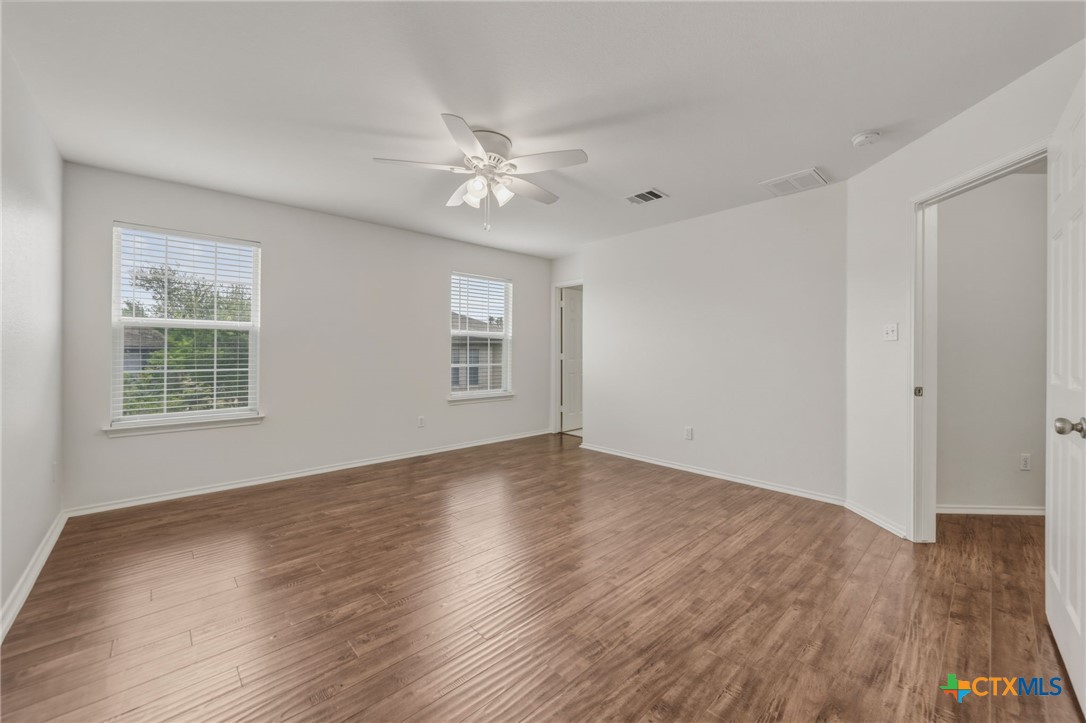 109 Comal Cove Elgin, TX 78621 - Photo 22 of 34 a view of empty room with wooden floor and fan