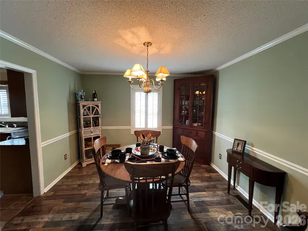 a dining room with furniture a chandelier and wooden floor