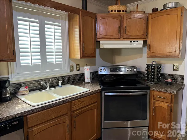 a kitchen with stainless steel appliances granite countertop a sink a stove and cabinets