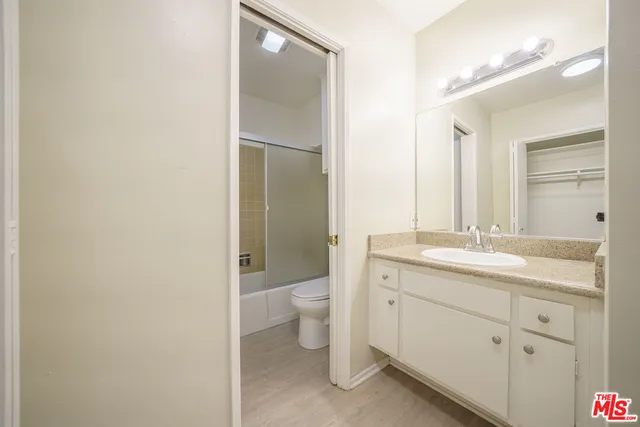 a bathroom with a granite countertop toilet a sink and a mirror