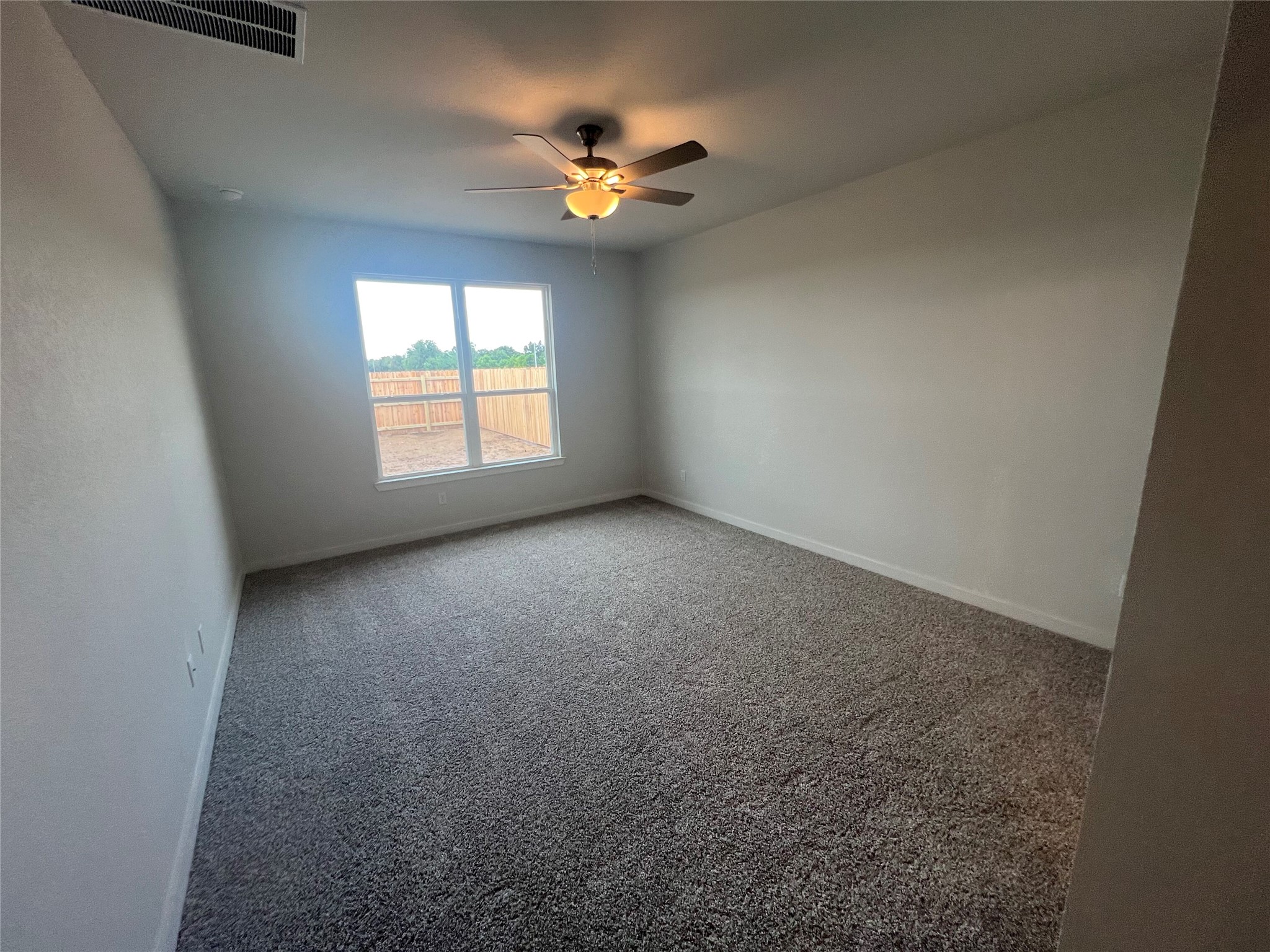 255 Gus Loop Georgetown, TX 78626 - Photo 17 of 24 A well-lit bedroom featuring a functional ceiling fan and a soft, inviting carpet.