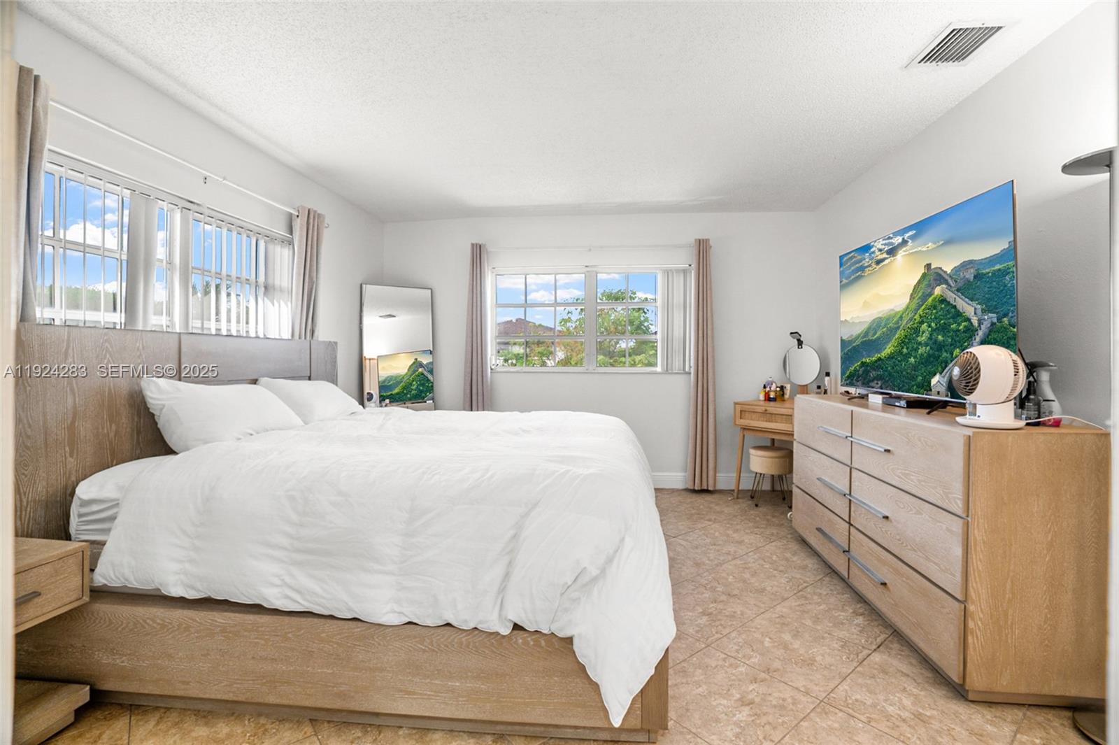 4605 Southwest 139th Court, Unit 814 Miami, FL 33175 - Photo 12 of 27 a bedroom with a large bed and a flat tv screen on dresser
