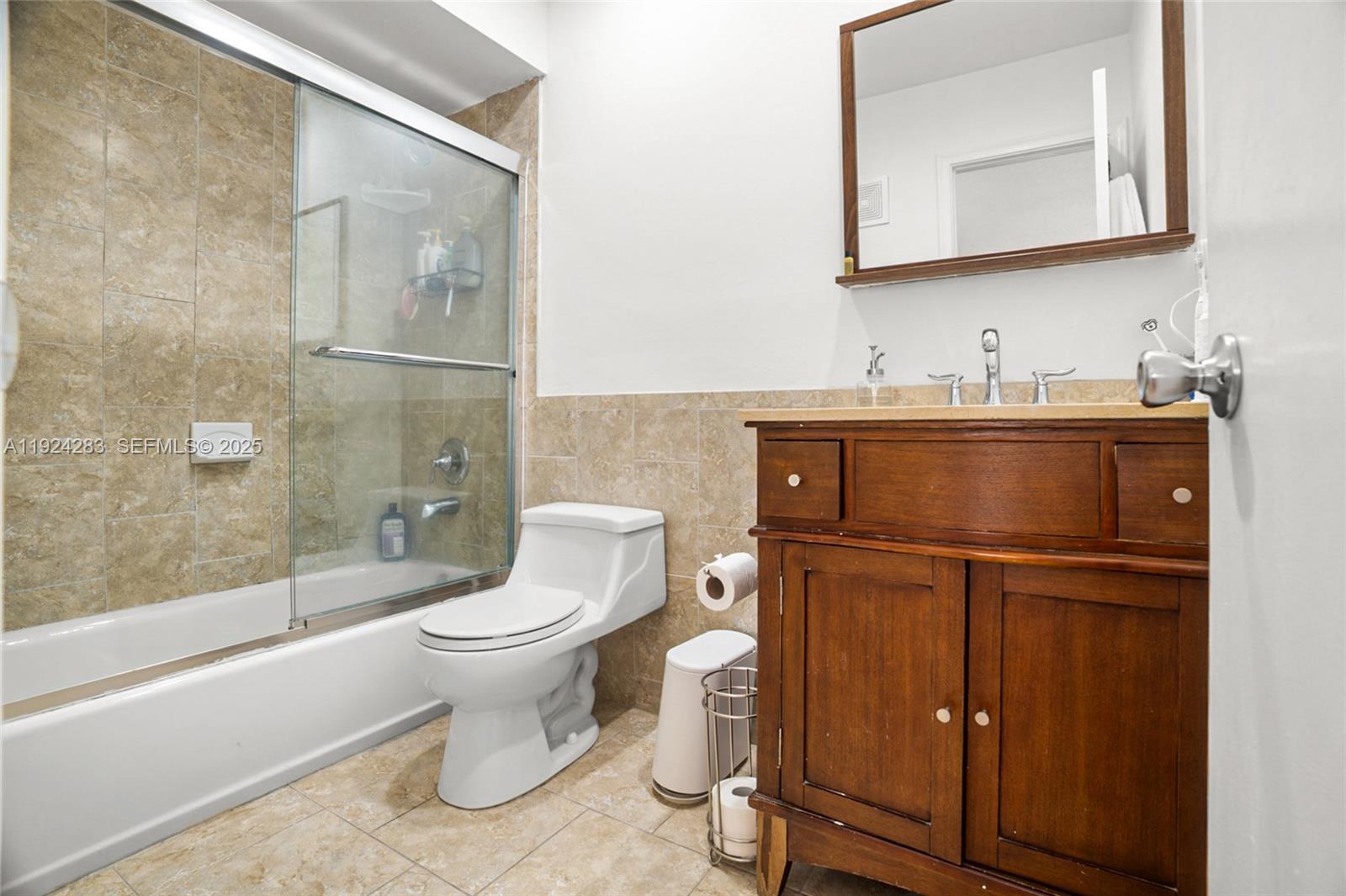 4605 Southwest 139th Court, Unit 814 Miami, FL 33175 - Photo 14 of 27 a bathroom with a granite countertop toilet sink and mirror