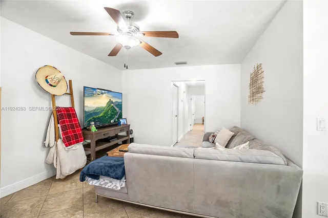 a living room with furniture a flat screen tv and a large window