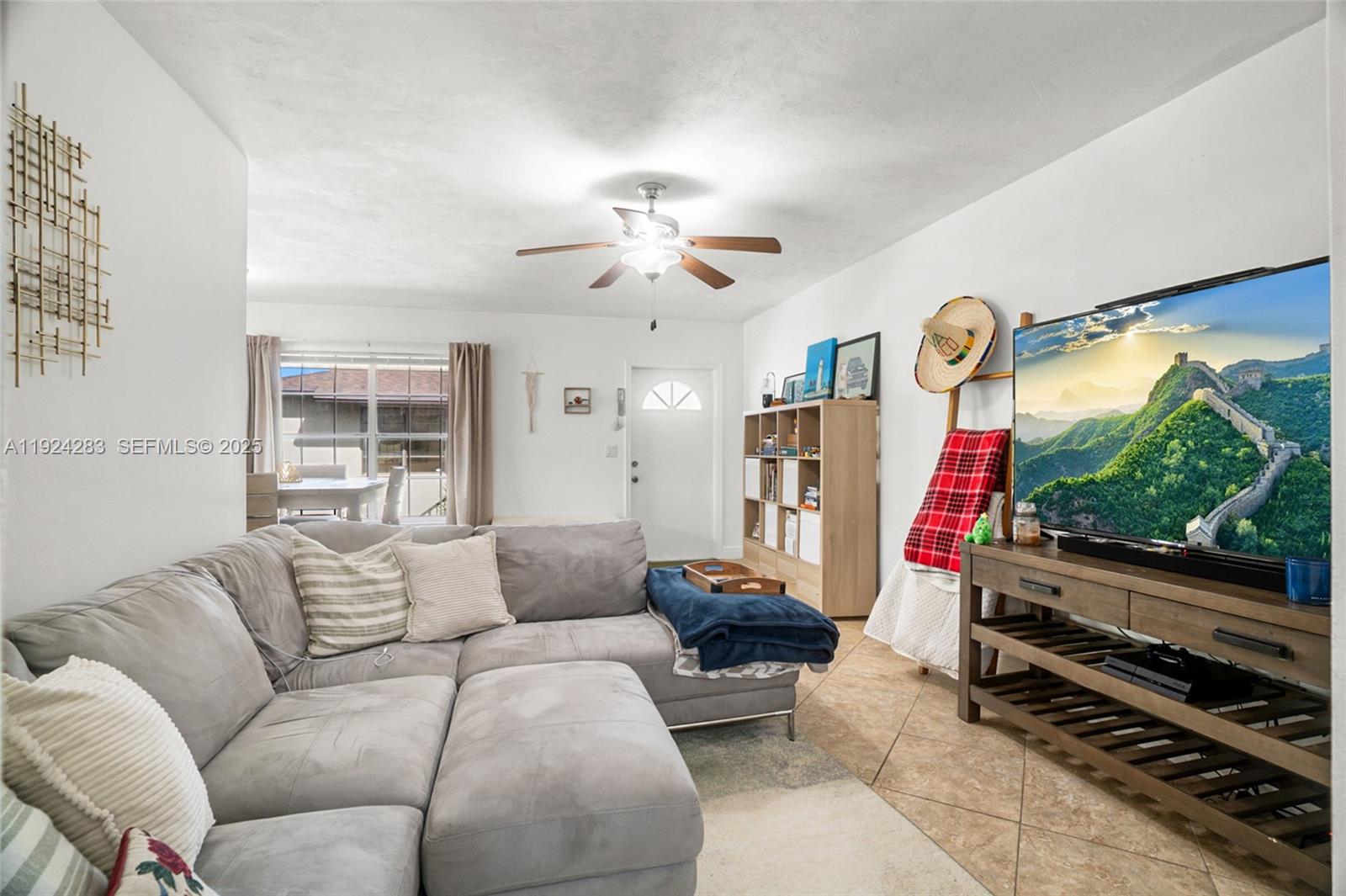 4605 Southwest 139th Court, Unit 814 Miami, FL 33175 - Photo 10 of 27 a living room with furniture a flat screen tv and a large window