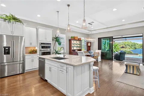 a kitchen with a refrigerator a stove and chairs