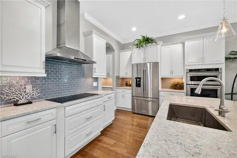 a kitchen with stainless steel appliances granite countertop a refrigerator sink and stove