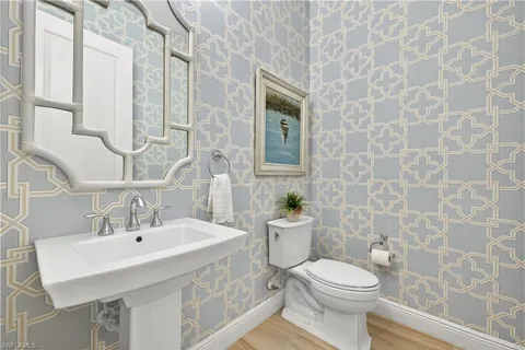 a bathroom with a sink a toilet and a mirror