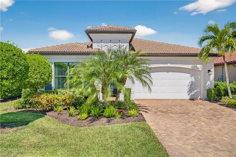 a view of a house with a yard and potted plants