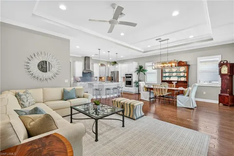 a living room with furniture kitchen view and a large window