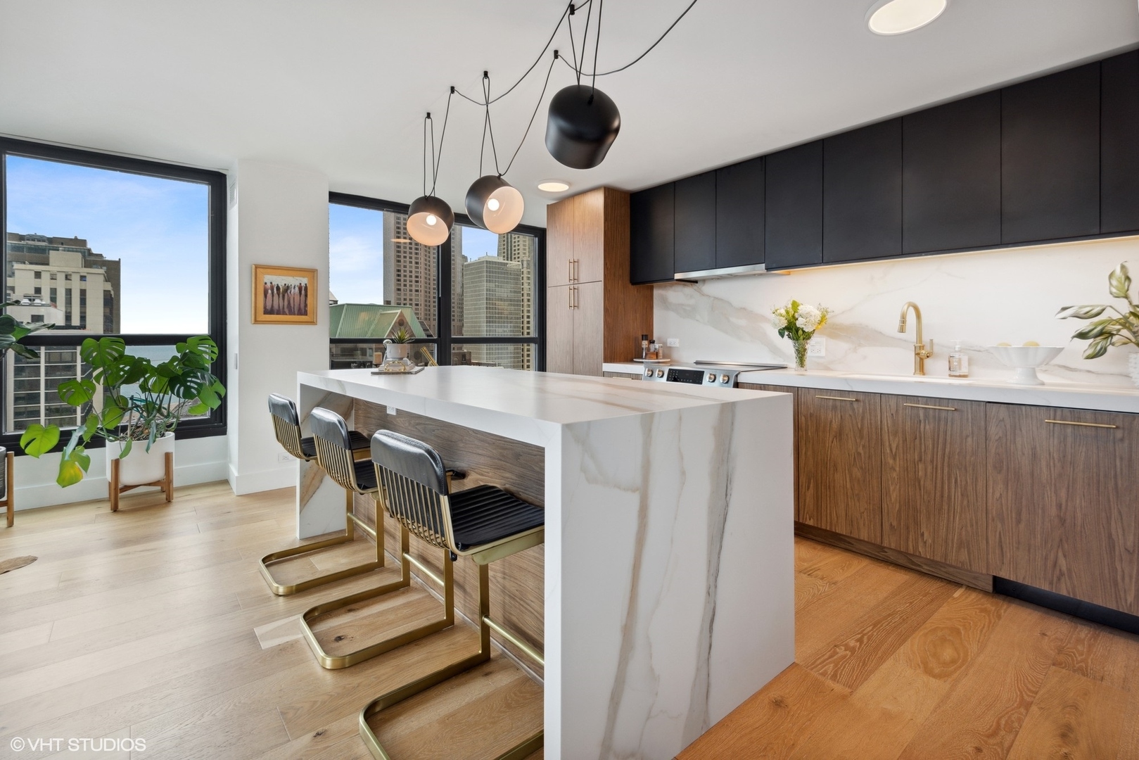 1030 North State Street, Unit 21E Chicago, IL 60610 - Photo 13 of 42 a kitchen with stainless steel appliances a table chairs in it and wooden floors