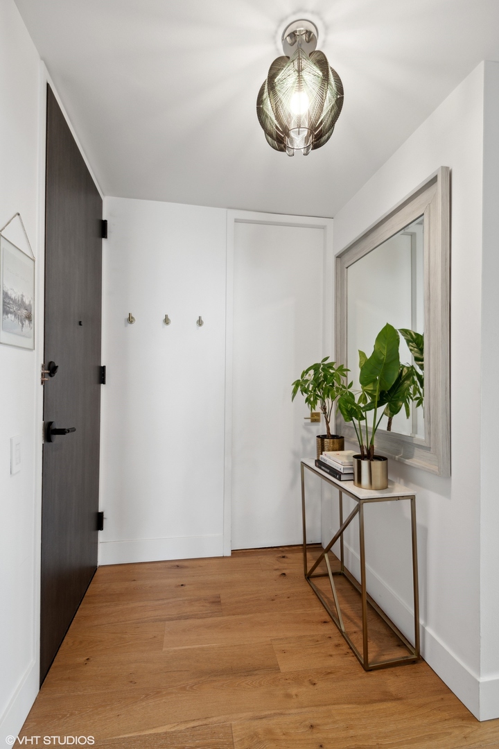 1030 North State Street, Unit 21E Chicago, IL 60610 - Photo 3 of 42 a view of a room with wooden floor and a potted plant