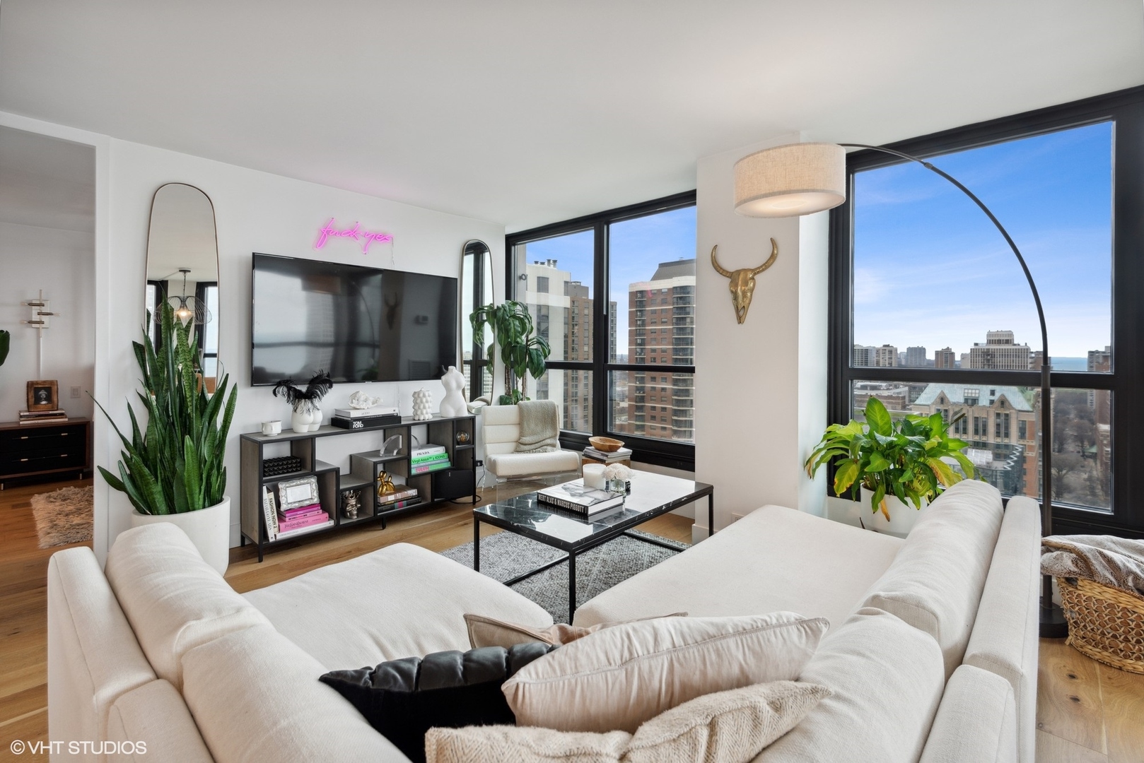 1030 North State Street, Unit 21E Chicago, IL 60610 - Photo 8 of 42 a living room with furniture a flat screen tv and a floor to ceiling window
