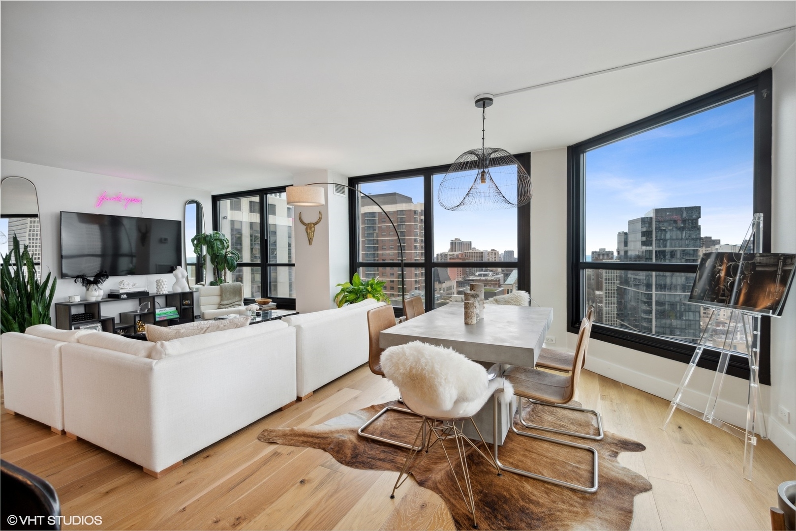 1030 North State Street, Unit 21E Chicago, IL 60610 - Photo 10 of 42 a living room with furniture a flat screen tv and a floor to ceiling window