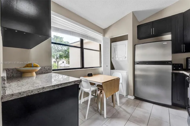 a kitchen with stainless steel appliances granite countertop a sink refrigerator and microwave