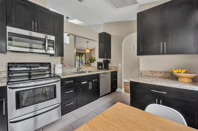 a kitchen with stainless steel appliances kitchen island granite countertop a stove a sink and a microwave