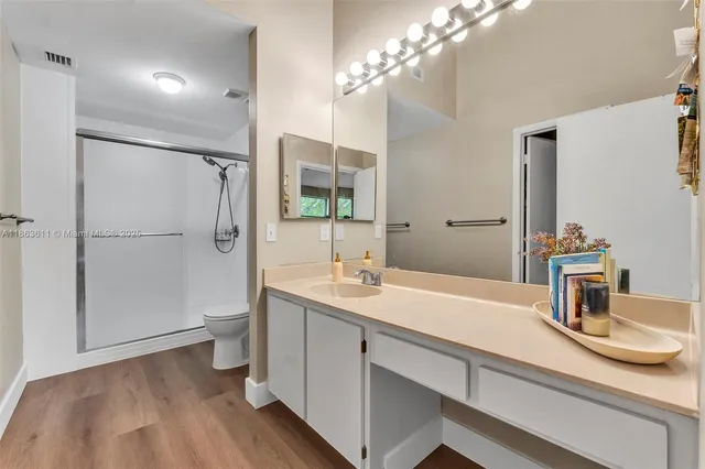 a bathroom with a sink toilet a mirror and shower