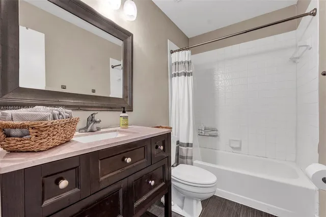 a bathroom with a granite countertop sink toilet mirror and shower