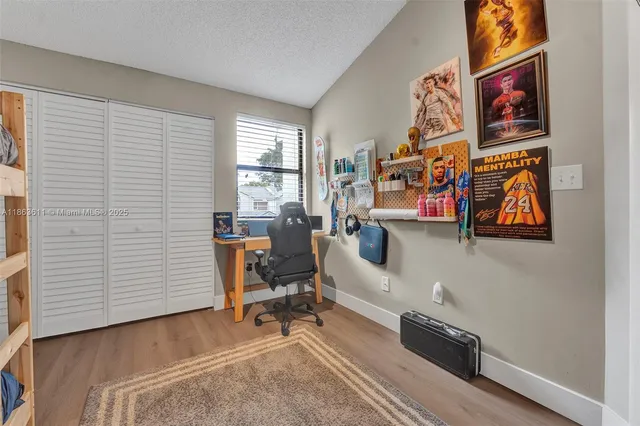 a view of a workspace with furniture and a window