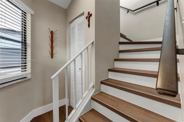 a view of staircase with wooden floor and fan