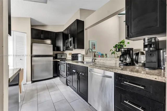 a kitchen with granite countertop a refrigerator and a sink