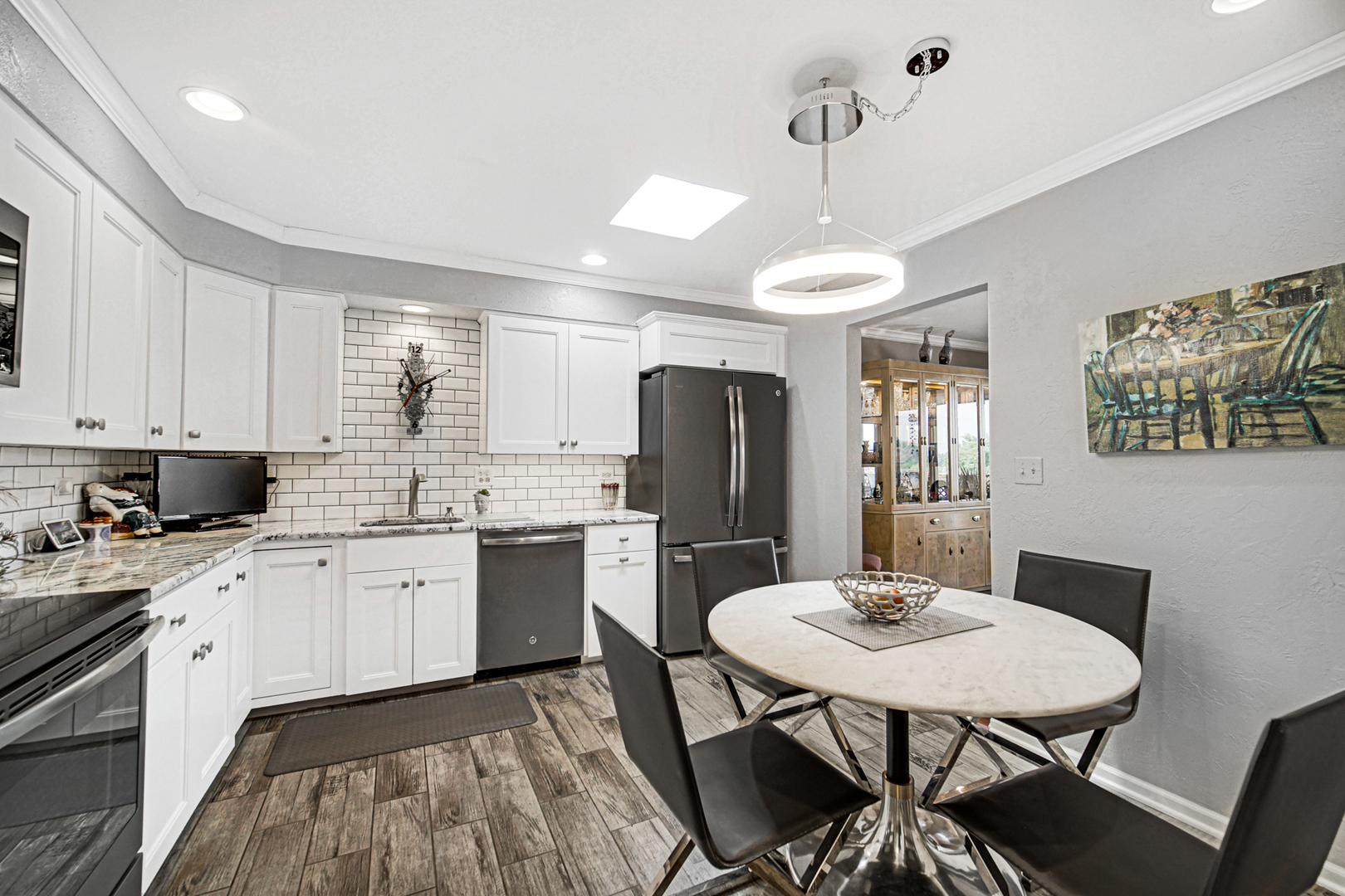 4000 Dundee Road, Unit 302 Northbrook, IL 60062 - Photo 4 of 12 a kitchen with stainless steel appliances kitchen island granite countertop a dining table chairs and sink